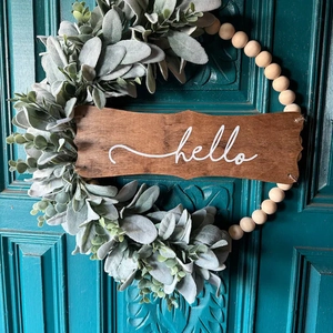 Fall wreath with Hello sign, eucalyptus leaves and wood beads on dark door