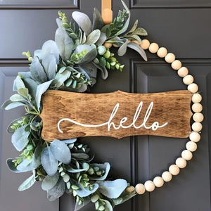 Hello wood bead wreath with eucalyptus greenery on a modern dark door display