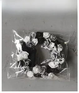 Detailed view of Halloween wreath with black and white roses in clear packaging