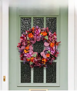 Detailed close-up of autumn harvest wreath with purple hydrangeas and colorful leaves