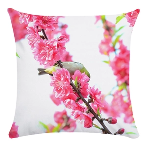 Detailed fabric texture of white cushion cover with pink blossoms and green bird