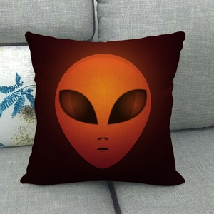Close-up of linen cushion cover with alien graphic on a grey fabric sofa