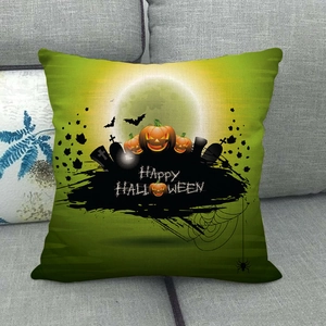 Detail of linen Halloween pillow cover with pumpkin lamp and bat print on a grey sofa