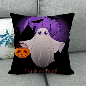 Detail of Halloween linen pillowcase with pumpkin and ghost print on a grey sofa
