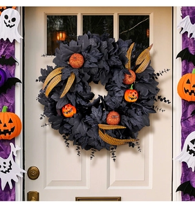 Detail of Halloween wreath with black maple leaves and orange pumpkins on white door