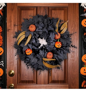 Macro shot of Halloween wreath with black maple leaves, orange pumpkins and golden feathers