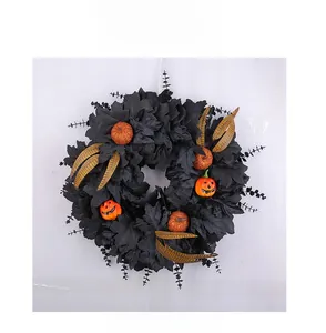 Macro detail of Halloween wreath with black maple leaves and glitter pumpkins decor