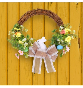 Close-up of Easter wreath with rattan base, pastel eggs, daisies, and a white bunny