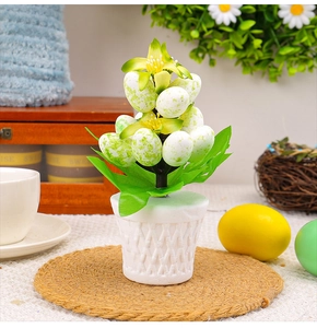 Detail of Easter artificial plant with yellow flowers and speckled foam eggs in woven pot