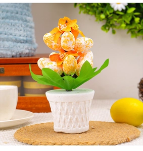 Detailed view of colorful speckled Easter eggs and small orange flowers in a mesh pot