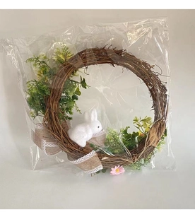 Detail of Easter wreath with white flocked bunny, green leaves and burlap bows decoration