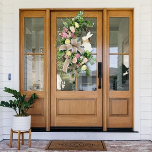Close-up of Easter wreath with burlap rabbit and faux peonies on wooden glass door