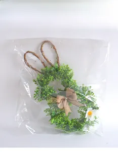 Easter bunny wreath with green leaves and burlap bow in protective plastic packaging