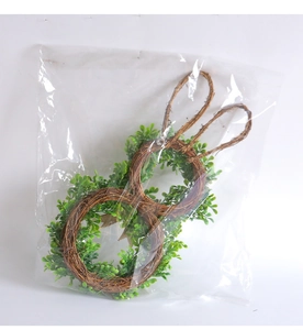 Detail of Easter bunny wreath showing natural rattan base and realistic green leaves
