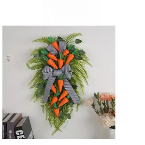 Close-up of Easter carrot door swag with green ferns and black white striped bow