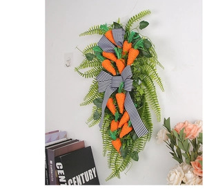 Detail of Easter carrot wall hanging with green ferns and striped bow on white wall