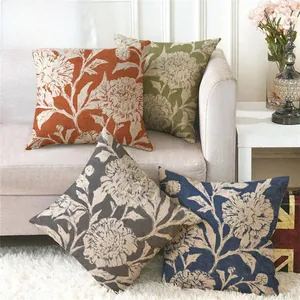 Set of four linen pillow covers with hand-painted floral patterns in a cozy living room