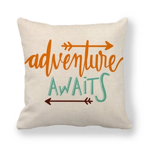 Detail of adventure AWAITS text on linen pillow cover with orange and teal arrows