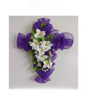 Dettaglio di ghirlanda pasquale a croce in rete viola con gigli bianchi e foglie