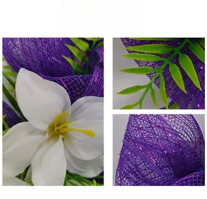 Dettaglio della trama a rete viola, fiori bianchi e foglie sulla ghirlanda di Pasqua
