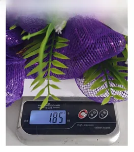 Dettaglio della decorazione in rete viola pesata su una bilancia che indica 185g