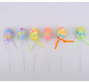 Detailed view of colorful Easter egg cake toppers with textured patterns and matching ribbons
