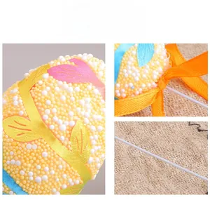 Close-up of Easter foam egg picks with colorful beads, ribbon bows and metal stakes