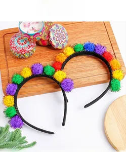Zoom sur des serre-têtes de carnaval à pompons colorés sur un support bois