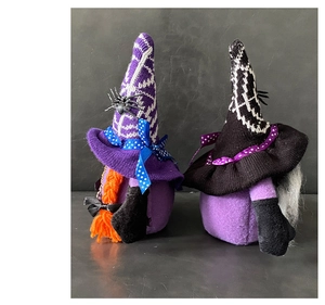 Detail of Halloween gnome dolls with spider patterns and knitted textures for desk decor