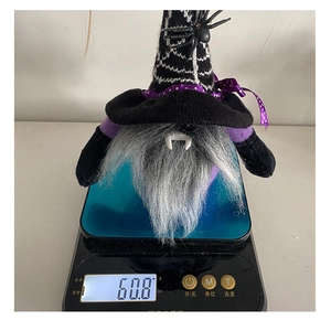 Close-up of a Halloween vampire gnome plush toy weighed at 60.8g on a digital scale