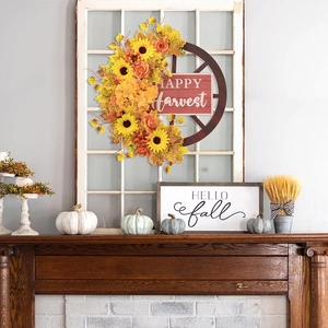 Dettaglio ghirlanda autunnale con girasoli su ruota di legno e scritta Happy Harvest