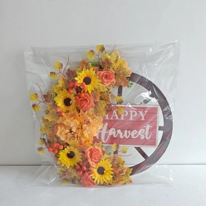 Dettaglio della corona di girasoli e acero su ruota con targa Happy Harvest autunnale