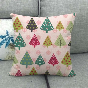 Detail of Christmas tree patterns and coarse linen texture on a pink throw pillow cover