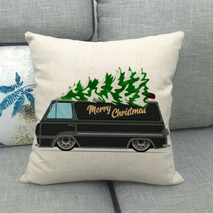 Linen Christmas pillow cover with vintage black van and green tree on a gray sofa
