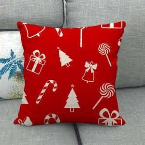 Housse de coussin de Noël en lin rouge avec motifs blancs sur canapé gris