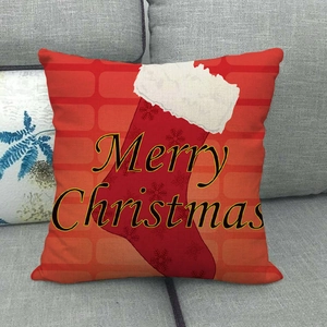 Housse de coussin Noël avec chaussettes rouges et texte Merry Christmas sur canapé gris
