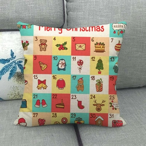 Détail de la housse de coussin calendrier de l'Avent de Noël avec motifs festifs sur canapé