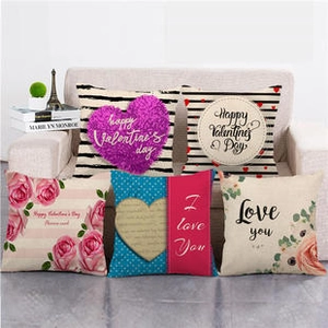 Close-up of linen pillow covers with Love and Valentine floral prints on a sofa