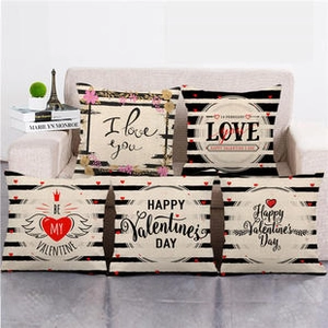 Valentine's Day linen pillow covers with red hearts and black stripes on a sofa