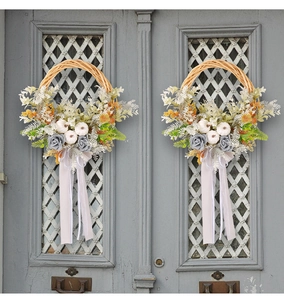 Détail de couronne de citrouille vintage sur portes en bois avec rubans et feuillage