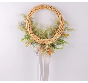 Vue détaillée d'une couronne en rotin faite main avec feuilles et ruban gris soyeux