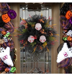 Close-up of Halloween wreath with scary bleeding skulls and mesh hanging on a wooden door