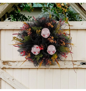 Close-up of Halloween horror wreath with black tulle and bloody doll heads on a door