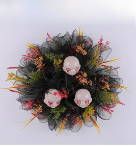 Close-up of Halloween horror wreath featuring bleeding baby heads and mesh gauze decor