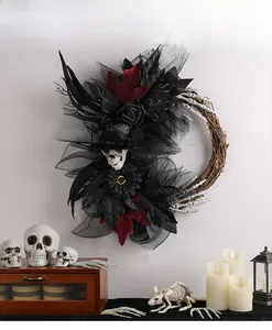 Détail couronne d'Halloween avec roses noires, crâne et maille sur base de rotin naturel