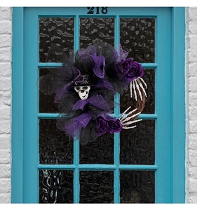 Détail d'une couronne d'Halloween avec crâne, filet violet, roses et chapeau de forme