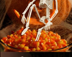 Close-up of a 40cm posable plastic skeleton in a bowl of festive Halloween candy corn