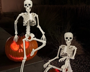 Detailed view of posable Halloween skeletons with movable joints in a night garden setting