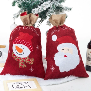 Detail of red burlap Christmas gift bags with Santa Claus and Snowman applique embroidery