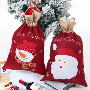 Detail of red burlap Christmas drawstring gift bags with Santa and Snowman embroidery